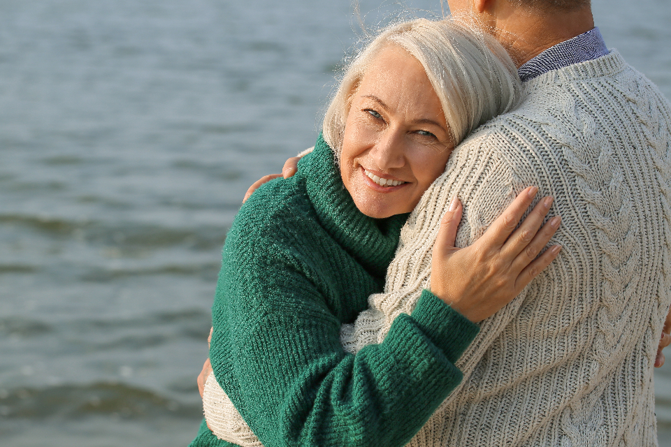 Couple de retraités enlacés au bord de la mer